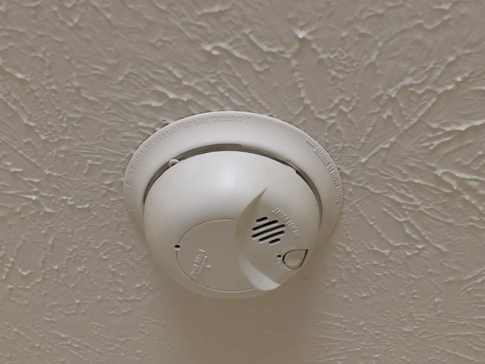A smoke, heat and carbon-monoxide detector installed on a Calgary ceiling by Singh Security Services.